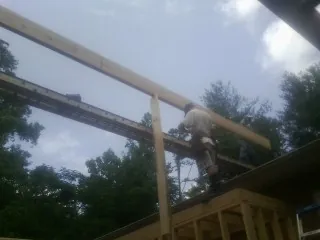 Carpenter setting a ridge beam over a new addition frame — Ice Dam Removal by Roofing Brothers in Northern Cambria